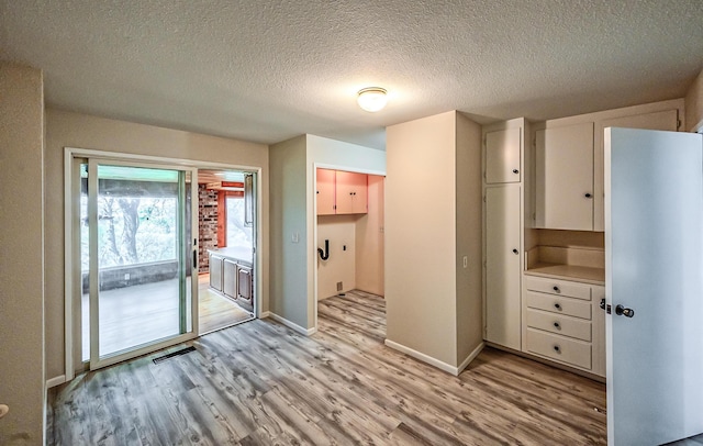 21790 Adobe Rd, Red Bluff, CA 96080 - kitchen with light wood-style floors, white cabinets, and a textured ceiling