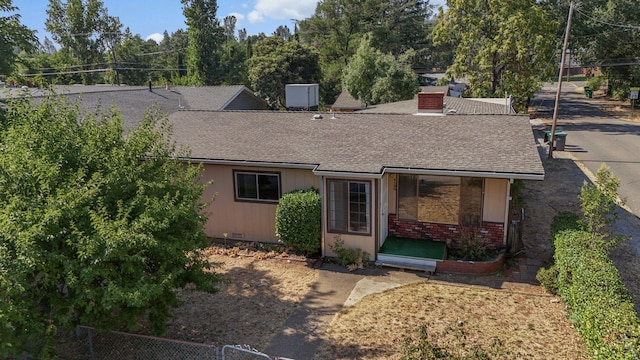 4100 Fort Peck St, Shasta Lake, CA 96019 - view of front facade with roof with shingles, brick siding, and a chimney