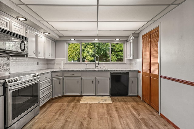 4100 Fort Peck St, Shasta Lake, CA 96019 - kitchen with black appliances, gray cabinets, light wood-style flooring, and backsplash