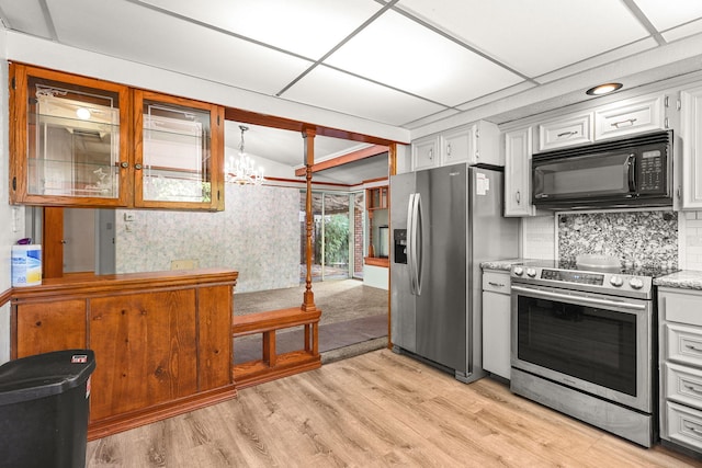 4100 Fort Peck St, Shasta Lake, CA 96019 - kitchen with appliances with stainless steel finishes, light wood-style floors, decorative backsplash, lofted ceiling, and white cabinets