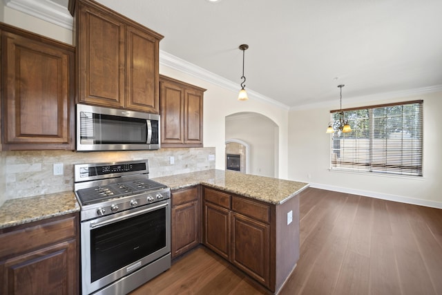 5569 Diamond Ridge Dr, Redding, CA 96003 - kitchen featuring appliances with stainless steel finishes, crown molding, arched walkways, decorative backsplash, and light stone counters