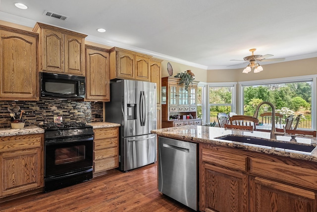 1533 Spanish Bay Dr, Redding, CA 96003 - kitchen with black appliances, light stone counters, decorative backsplash, dark wood finished floors, and crown molding