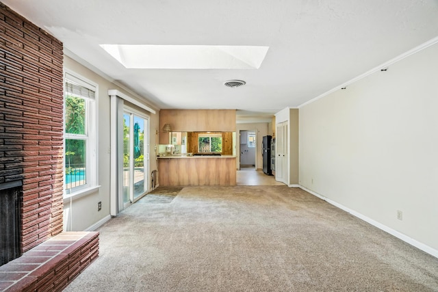 1198 Denton Way, Redding, CA 96002 - unfurnished living room with a skylight, light carpet, a brick fireplace, and crown molding