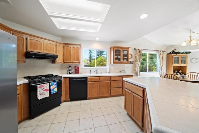 2790 Citrine Ave, Redding, CA 96001 - kitchen with black appliances, plenty of natural light, under cabinet range hood, backsplash, and lofted ceiling