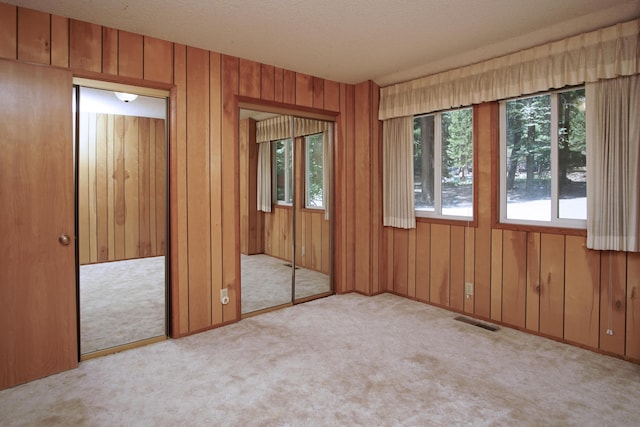 30839 Tinkerbell Ln, Shingletown, CA 96088 - unfurnished bedroom with multiple windows, carpet floors, two closets, and wooden walls