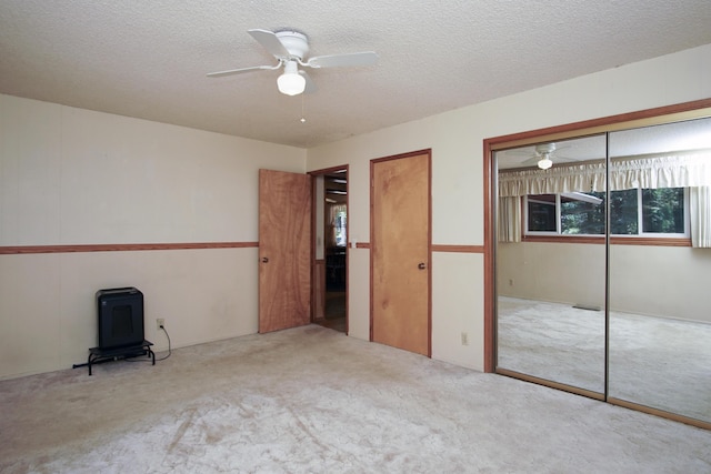 30839 Tinkerbell Ln, Shingletown, CA 96088 - unfurnished bedroom with carpet, a wood stove, a textured ceiling, and a ceiling fan