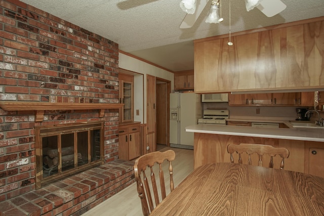 30839 Tinkerbell Ln, Shingletown, CA 96088 - kitchen featuring white appliances, light wood-style floors, a ceiling fan, light countertops, and a textured ceiling