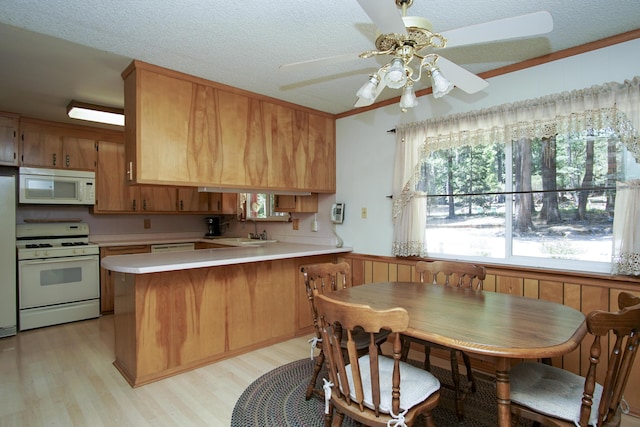 30839 Tinkerbell Ln, Shingletown, CA 96088 - kitchen with white appliances, light wood-style floors, light countertops, a peninsula, and a ceiling fan