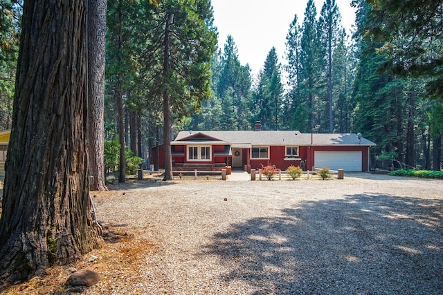 30839 Tinkerbell Ln, Shingletown, CA 96088 - single story home with an attached garage, driveway, a forest view, and a chimney