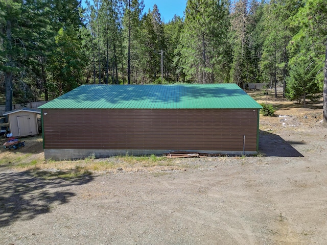 311 Ward Placer Pl, Weaverville, CA 96093 - view of home's exterior featuring a metal roof, a storage shed, and a view of trees