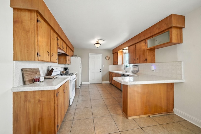 2045 Washington Ave, Red Bluff, CA 96080 - kitchen featuring white range with gas cooktop, light countertops, decorative backsplash, and brown cabinets