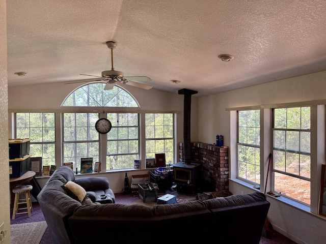 11941 Atkins Rd, Whitmore, CA 96096 - living room with a wood stove, a ceiling fan, a textured ceiling, vaulted ceiling, and carpet flooring