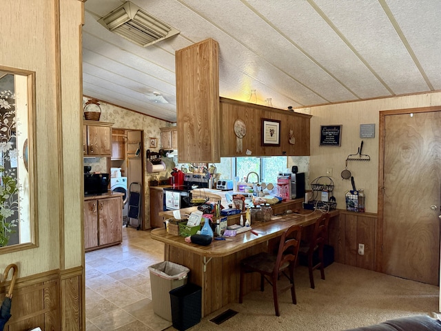 11941 Atkins Rd, Whitmore, CA 96096 - bar featuring vaulted ceiling, washer / clothes dryer, wallpapered walls, and wooden walls