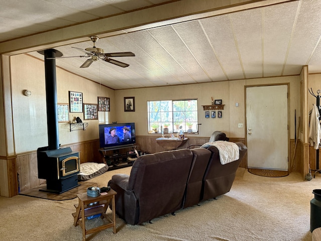 11941 Atkins Rd, Whitmore, CA 96096 - carpeted living room with a wood stove, wood walls, a ceiling fan, wainscoting, and vaulted ceiling