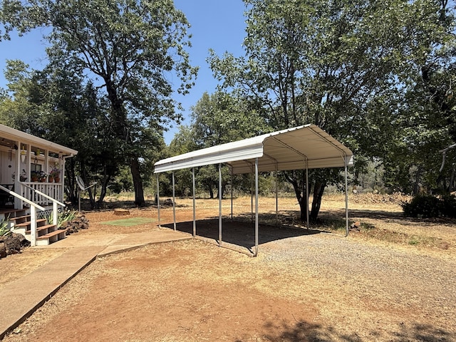 11941 Atkins Rd, Whitmore, CA 96096 - view of yard featuring dirt driveway, a detached carport, and view of wooded area