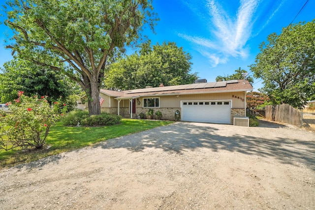 24470 Oklahoma Ave, Red Bluff, CA 96080 - ranch-style home featuring brick siding, an attached garage, solar panels, and driveway