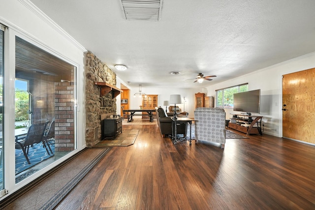 24470 Oklahoma Ave, Red Bluff, CA 96080 - living area with dark wood-style floors, a ceiling fan, crown molding, a textured ceiling, and a wood stove