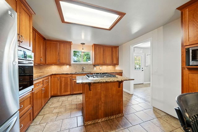24470 Oklahoma Ave, Red Bluff, CA 96080 - kitchen featuring appliances with stainless steel finishes, tasteful backsplash, brown cabinets, and stone countertops