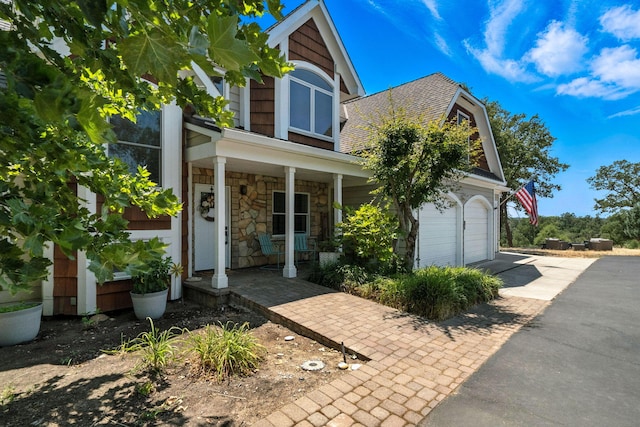 23795 Deer Canyon Rd, Millville, CA 96062 - view of front facade with a porch, asphalt driveway, a garage, stone siding, and a shingled roof
