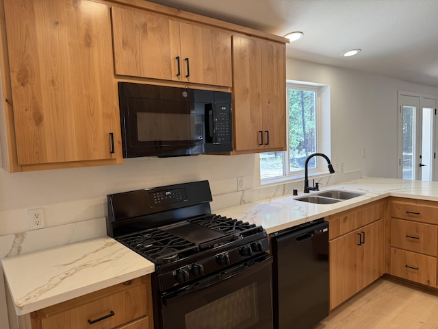 10360 Ritts Mill Rd, Shingletown, CA 96088 - kitchen featuring black appliances, light wood-style floors, light stone counters, and a peninsula