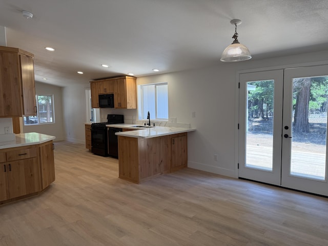 10360 Ritts Mill Rd, Shingletown, CA 96088 - kitchen with black appliances, a peninsula, light wood-style floors, light countertops, and french doors