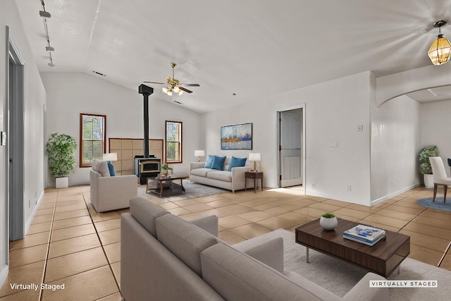 12526 Glide Way, Redding, CA 96003 - living room featuring a wood stove, vaulted ceiling, light tile patterned floors, arched walkways, and ceiling fan
