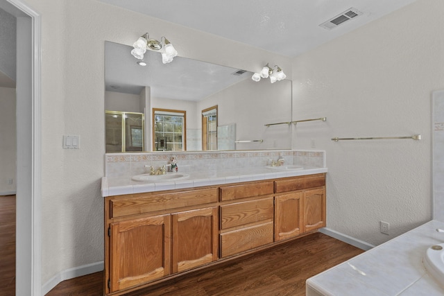 12526 Glide Way, Redding, CA 96003 - bathroom with double vanity, wood finished floors, a shower with shower door, and a textured wall