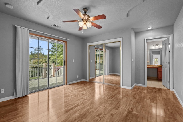 12526 Glide Way, Redding, CA 96003 - unfurnished bedroom with access to outside, wood finished floors, a textured ceiling, connected bathroom, and a closet