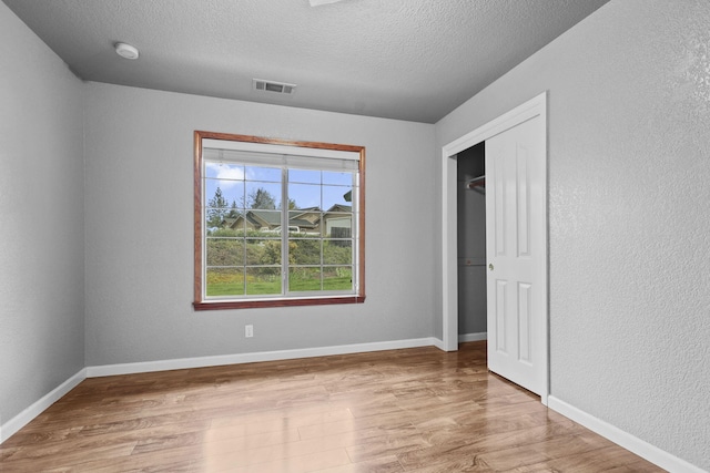 12526 Glide Way, Redding, CA 96003 - unfurnished bedroom with wood finished floors, a textured ceiling, and a closet
