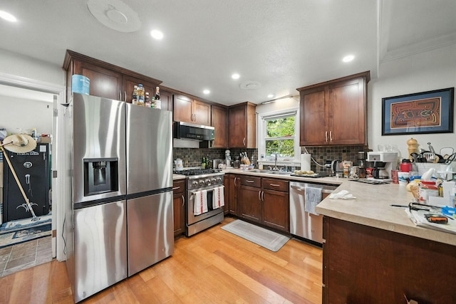 1635 Pleasant St, Redding, CA 96001 - kitchen featuring appliances with stainless steel finishes, light wood-style flooring, decorative backsplash, light countertops, and recessed lighting
