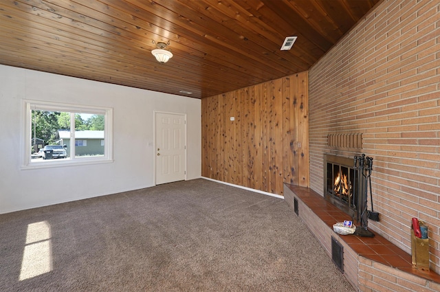 210 Sherman St, Yreka, CA 96097 - unfurnished living room featuring a brick fireplace, carpet flooring, wood ceiling, and wooden walls