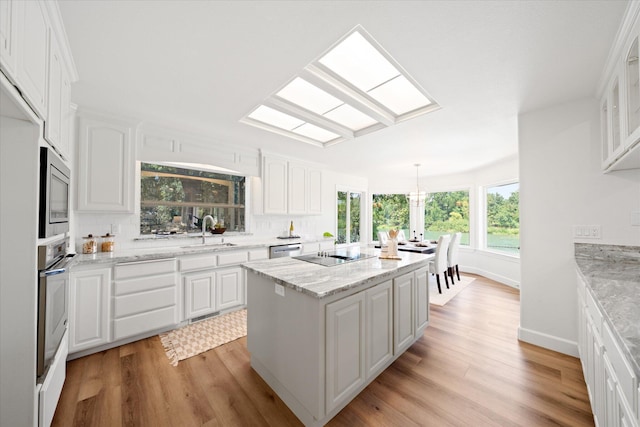 2949 Felstet Ln, Redding, CA 96001 - kitchen featuring appliances with stainless steel finishes, light wood-style floors, white cabinets, and tasteful backsplash