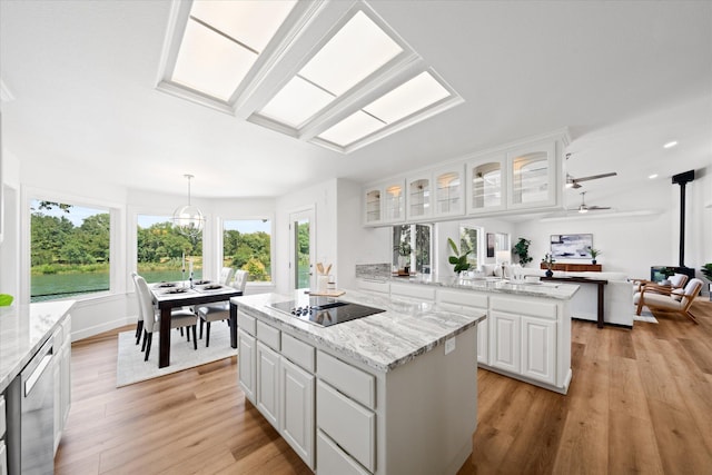 2949 Felstet Ln, Redding, CA 96001 - kitchen with black electric cooktop, a center island, healthy amount of natural light, and light wood finished floors