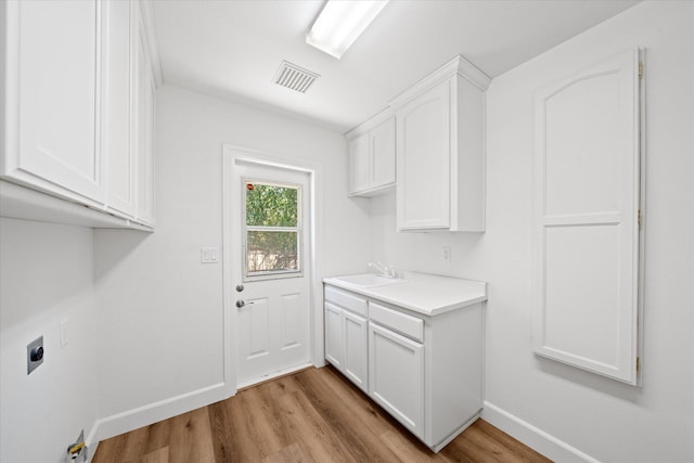 2949 Felstet Ln, Redding, CA 96001 - washroom with hookup for an electric dryer, cabinet space, and light wood-style floors