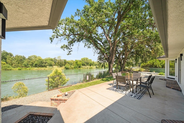 2949 Felstet Ln, Redding, CA 96001 - fenced backyard featuring a water view, a patio, outdoor dining area, and view of wooded area
