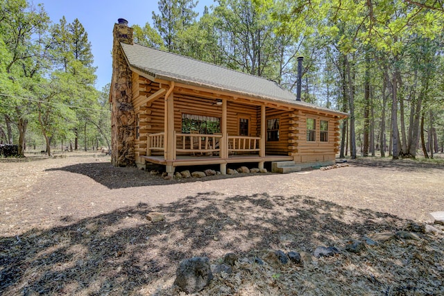 27401 Goodman Rd, Fall River Mills, CA 96028 - view of front of house featuring log exterior, a chimney, and a wooden deck