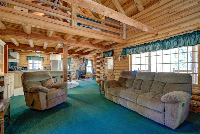 27401 Goodman Rd, Fall River Mills, CA 96028 - living area featuring a wood ceiling with exposed beams, log walls, carpet flooring, plenty of natural light, and a wood stove