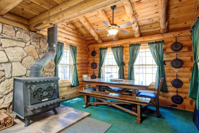 27401 Goodman Rd, Fall River Mills, CA 96028 - carpeted dining room featuring a wood stove, wood ceiling, ceiling fan, and rustic walls