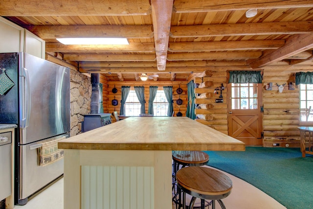 27401 Goodman Rd, Fall River Mills, CA 96028 - kitchen featuring a wood ceiling with exposed beams, log walls, carpet floors, freestanding refrigerator, and wood counters