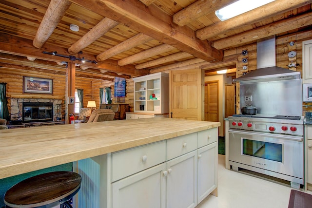 27401 Goodman Rd, Fall River Mills, CA 96028 - kitchen with butcher block countertops, designer range, a wood ceiling with exposed beams, ventilation hood, and rustic walls