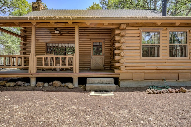 27401 Goodman Rd, Fall River Mills, CA 96028 - property entrance with log exterior, a chimney, ceiling fan, a porch, and roof with shingles