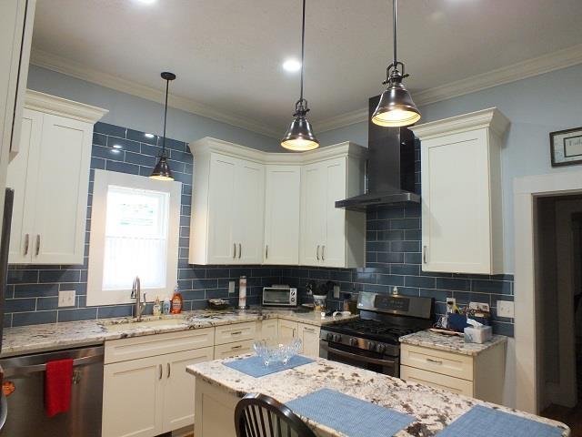 kitchen with range with gas cooktop, backsplash, wall chimney exhaust hood, and dishwasher