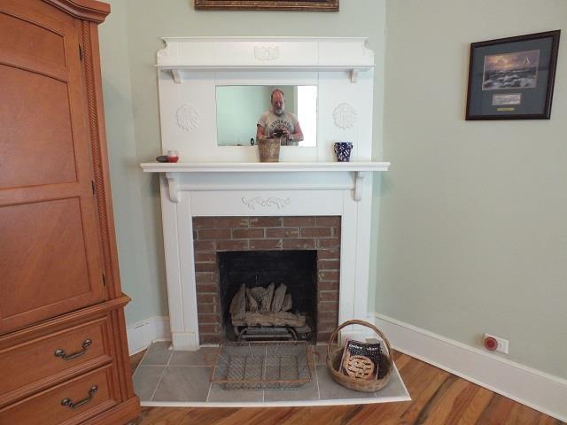 interior space with a brick fireplace and wood-type flooring