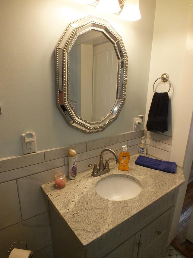 bathroom featuring oversized vanity and tasteful backsplash