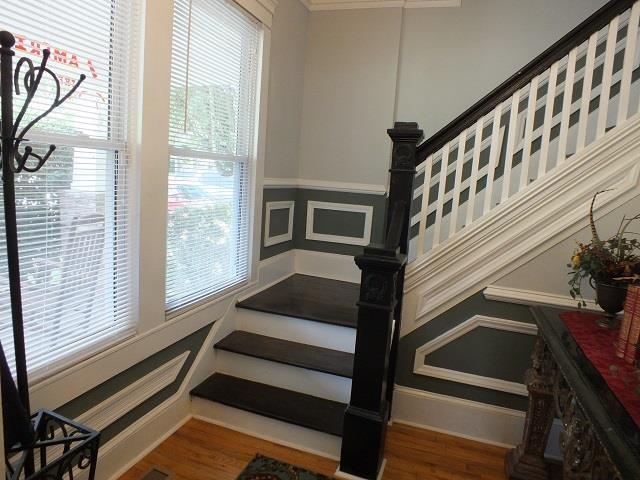 stairway with plenty of natural light and dark hardwood / wood-style floors