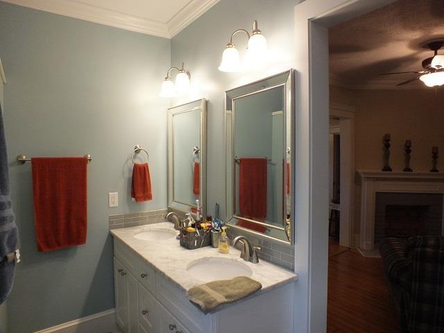 bathroom with crown molding, ceiling fan, dual sinks, oversized vanity, and hardwood / wood-style flooring