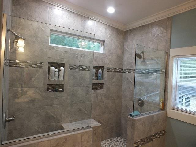 bathroom featuring crown molding, a wealth of natural light, and walk in shower