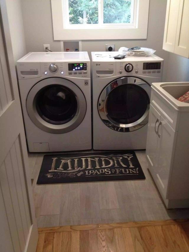 laundry room featuring washer hookup, hookup for an electric dryer, light hardwood / wood-style flooring, cabinets, and separate washer and dryer