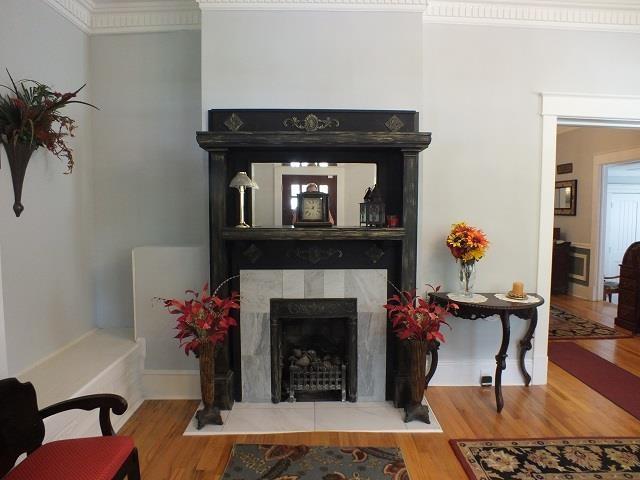 living room with a tile fireplace, ornamental molding, and light hardwood / wood-style flooring