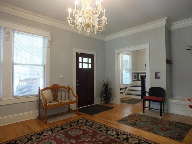 foyer entrance featuring a notable chandelier, a wealth of natural light, and wood-type flooring